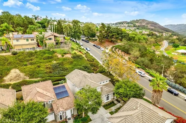 an aerial view of residential houses with outdoor space and trees