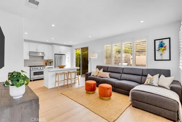 a living room with furniture kitchen view and a window