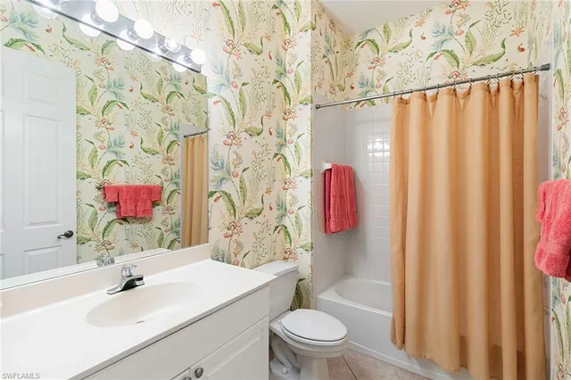 a bathroom with a sink a toilet and shower curtain