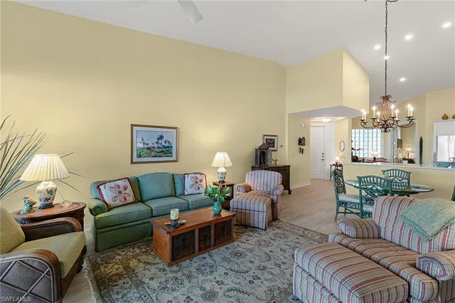 a living room with furniture a chandelier and a dining table