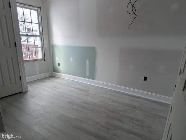 a view of an empty room with wooden floor and entryway