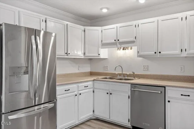 a kitchen with stainless steel appliances white cabinets and a refrigerator