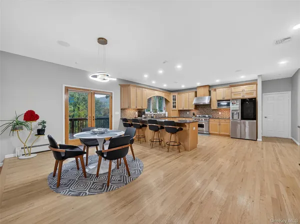 a living room with furniture and kitchen view with wooden floor