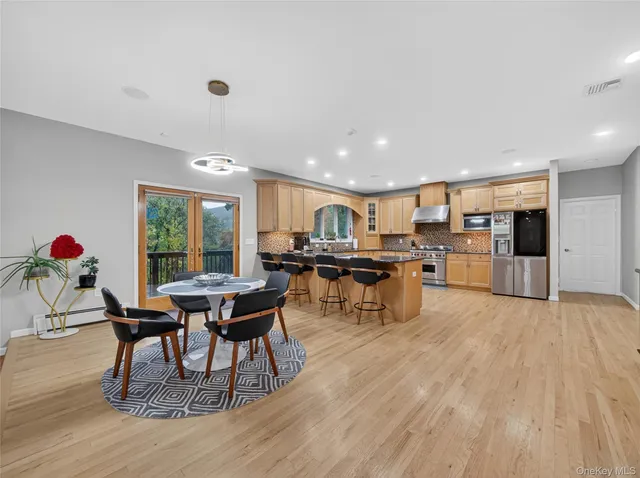 a living room with furniture and kitchen view with wooden floor
