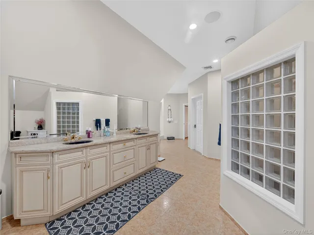 a large bathroom with a double vanity sink a mirror and a shower