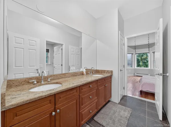 a bathroom with a granite countertop double vanity sink and mirror