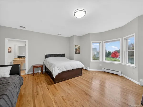 a spacious bedroom with a bed and glass window
