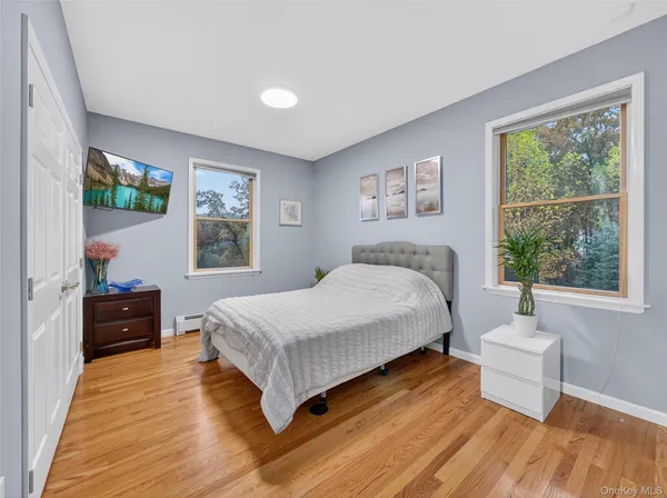 a spacious bedroom with a bed and wooden floor