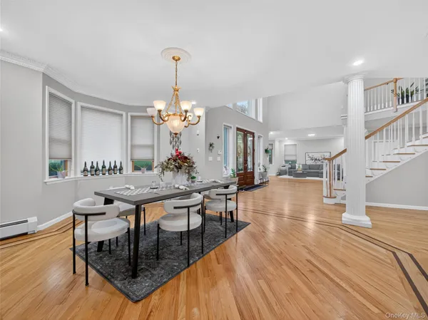 a dining room with wooden floor a chandelier a wooden table and chairs