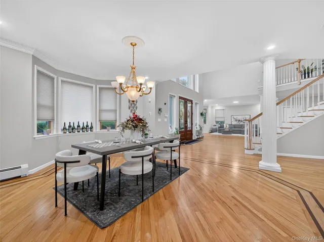 a dining room with wooden floor a chandelier a wooden table and chairs