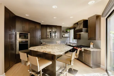 a kitchen with stainless steel appliances granite countertop a sink stove and cabinets