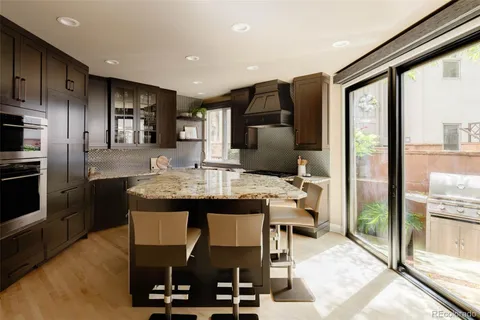 a kitchen with stainless steel appliances kitchen island granite countertop a refrigerator and microwave