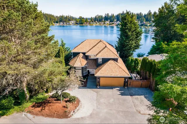 an aerial view of a house with a yard and lake view