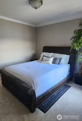 a large bed sitting in a bedroom next to a window