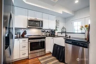 a kitchen with granite countertop a stove sink and refrigerator
