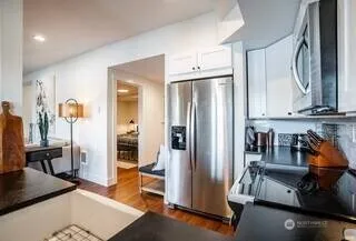 a view of a kitchen with refrigerator and workspace