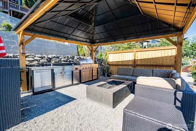 a view of a roof deck with couches under an umbrella