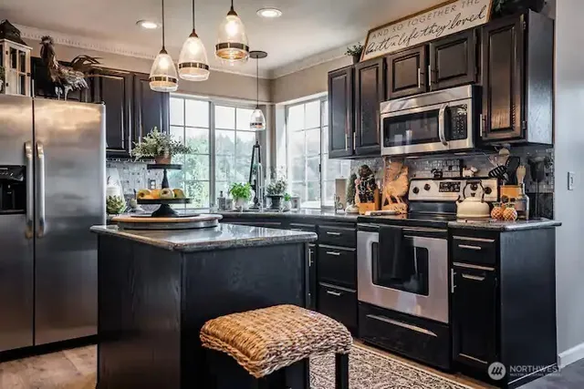 a kitchen with stainless steel appliances granite countertop a sink a stove and a refrigerator