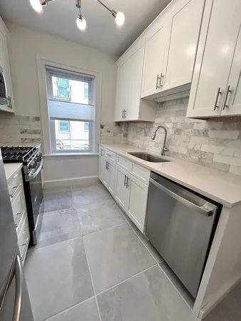 a kitchen with a sink a stove and cabinets