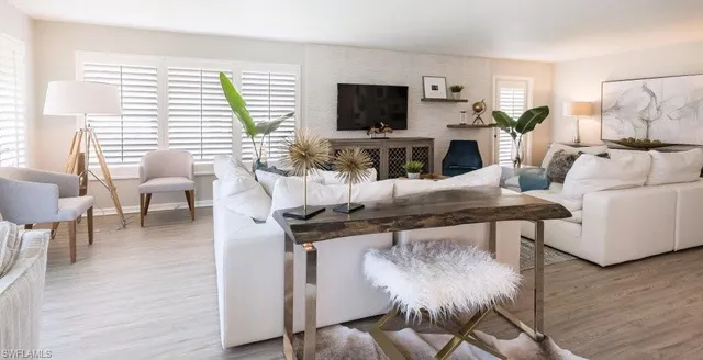 a living room with furniture a flat screen tv and a large window