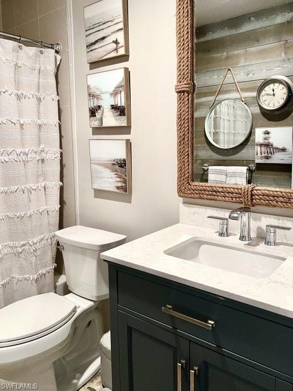 12 Knights Bridge Road, Unit A32 Naples, FL 34112 - Photo 12 of 17 a bathroom with a granite countertop toilet sink and mirror