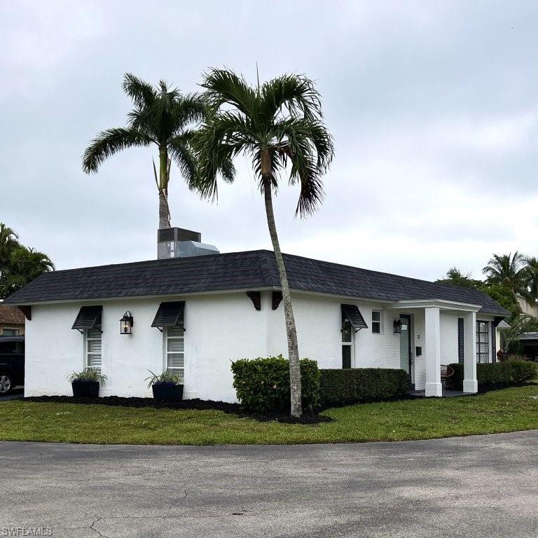 12 Knights Bridge Road, Unit A32 Naples, FL 34112 - Photo 16 of 17 a front view of a house with a yard and garage