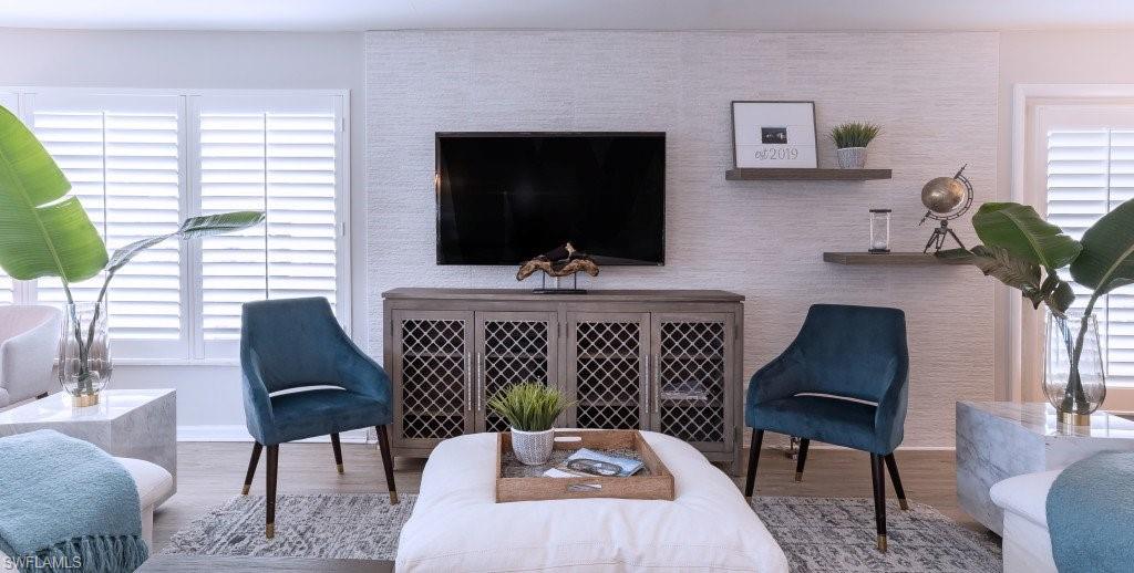 12 Knights Bridge Road, Unit A32 Naples, FL 34112 - Photo 2 of 17 a living room with furniture and a flat screen tv