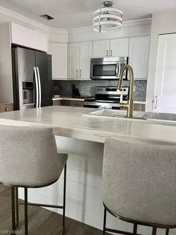 a kitchen with stainless steel appliances granite countertop a stove a refrigerator a microwave a sink and a refrigerator