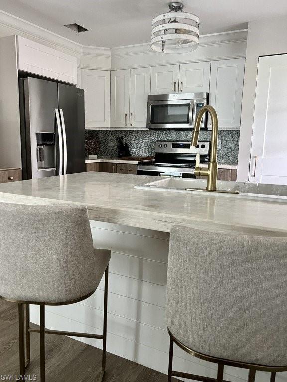 12 Knights Bridge Road, Unit A32 Naples, FL 34112 - Photo 4 of 17 a kitchen with stainless steel appliances granite countertop a stove a refrigerator a microwave a sink and a refrigerator