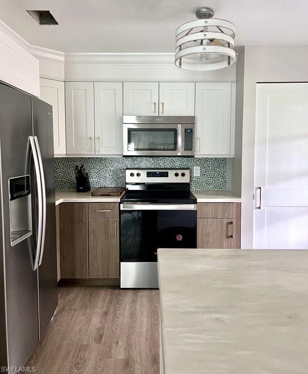 12 Knights Bridge Road, Unit A32 Naples, FL 34112 - Photo 5 of 17 a kitchen with stainless steel appliances a stove a sink and a refrigerator