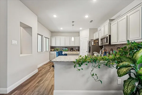 a kitchen with stainless steel appliances kitchen island sink stove and cabinets