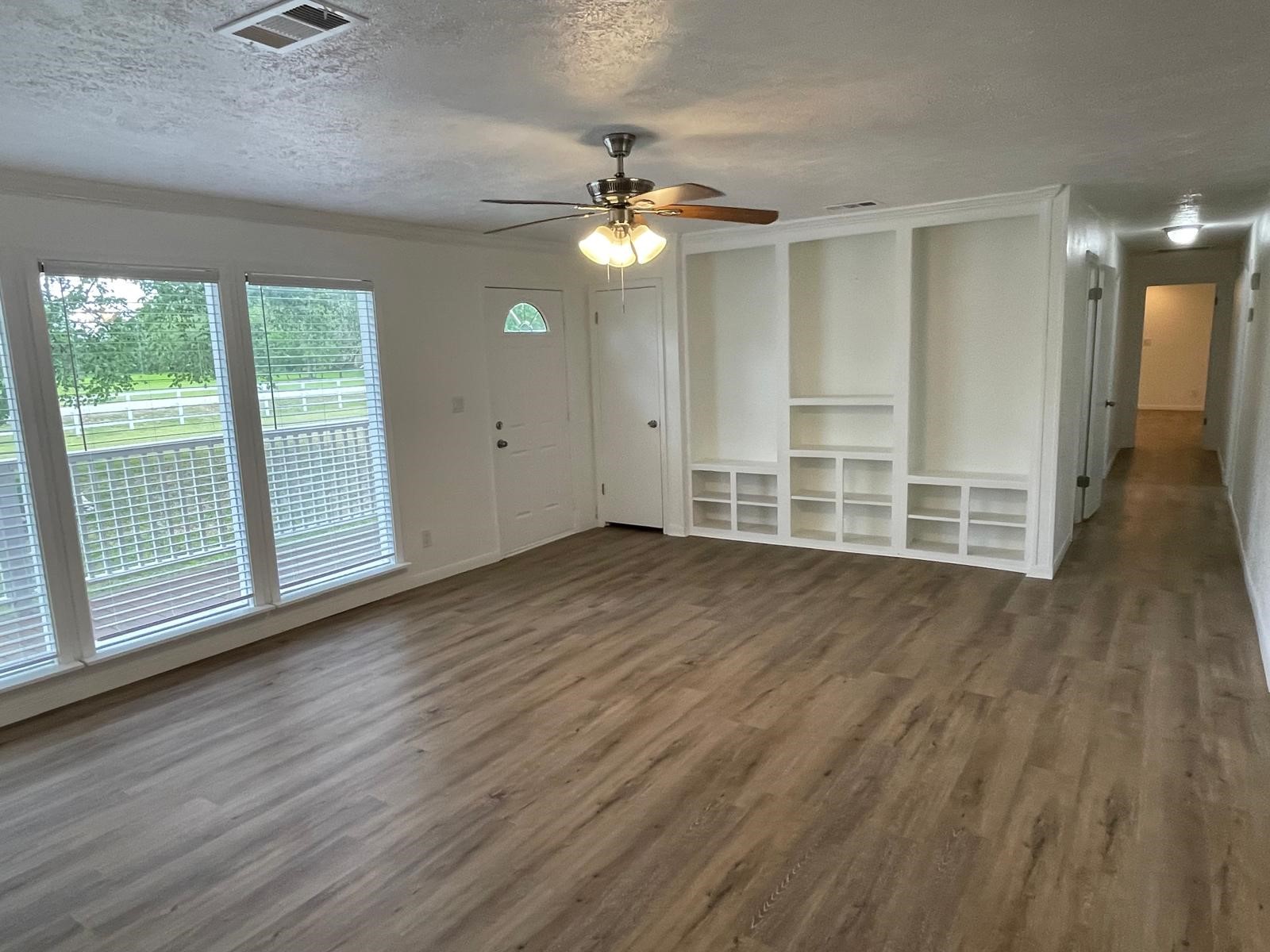 335 Carroll Road Richmond, TX 77469 - Photo 9 of 25 wooden floor in an empty room with a window