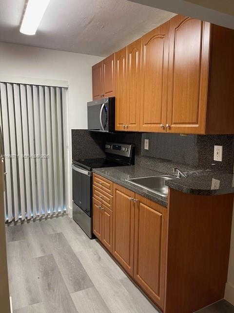 1852 Southwest 7th Street, Unit 203 Miami, FL 33135 - Photo 13 of 16 a view of a kitchen with granite countertop stainless steel appliances stove top oven and cabinets