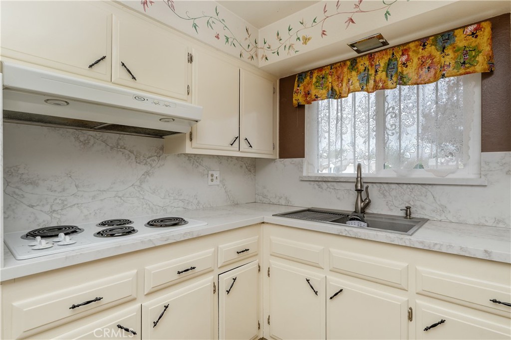 28121 Pebble Beach Drive Menifee, CA 92586 - Photo 12 of 35 a kitchen with a sink a window and cabinets
