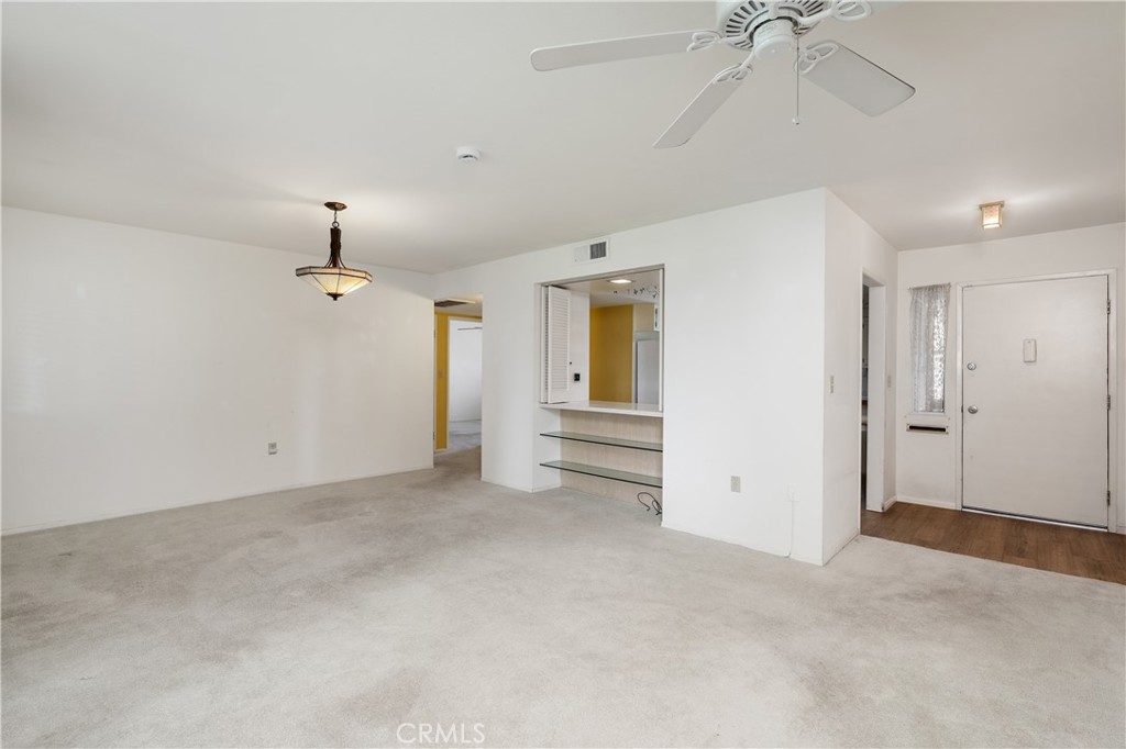 28121 Pebble Beach Drive Menifee, CA 92586 - Photo 8 of 35 an empty room with chandelier fan and windows