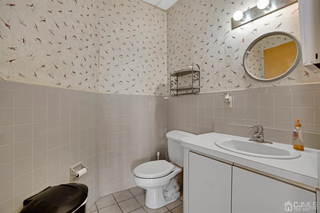 1656 Oak Tree Road, Unit 2 Edison, NJ 08820 - Photo 19 of 19 a bathroom with a sink a toilet and a mirror