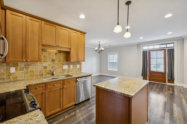 a kitchen with stainless steel appliances granite countertop a stove a sink and a microwave