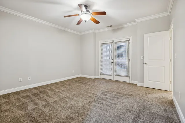 a view of an empty room and chandelier fan