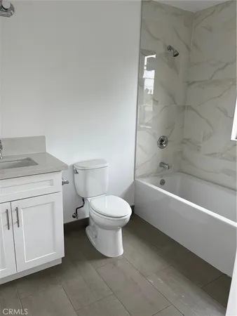 a bathroom with a toilet a sink a mirror and bathtub