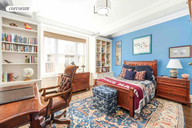 a bedroom with a bed wooden floor and a large window