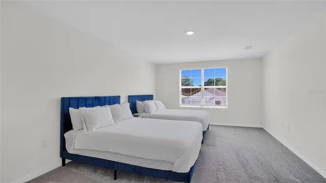 a bedroom with a bed and painting on the wall