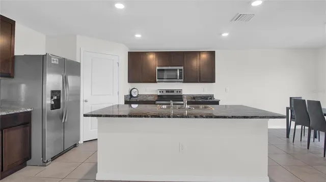 a kitchen with stainless steel appliances granite countertop a sink and a refrigerator