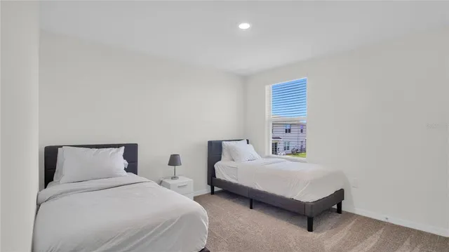 a bedroom with two beds and painting on the wall