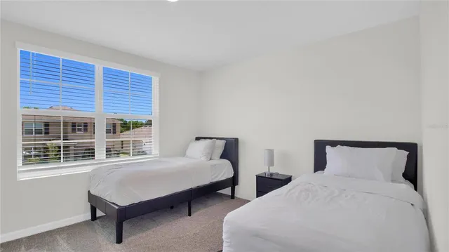 a bedroom with two beds and a window