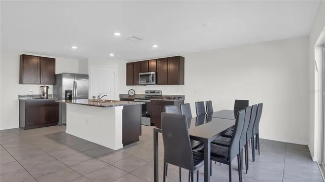 a kitchen with a dining table chairs appliances and cabinets