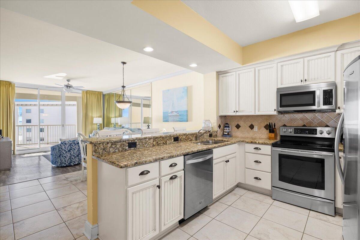 1150 Santa Rosa Boulevard, Unit 520 Fort Walton Beach, FL 32548 - Photo 3 of 25 a kitchen with stainless steel appliances granite countertop a stove a sink and a microwave