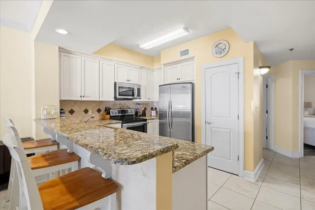 a kitchen with stainless steel appliances granite countertop a refrigerator and a stove