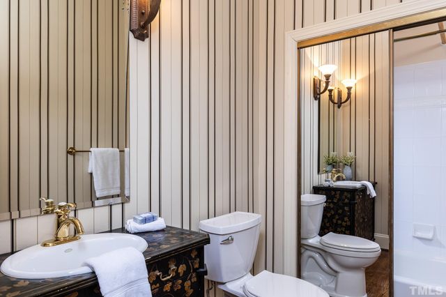 a bathroom with a toilet a sink and a mirror