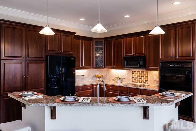a kitchen with stainless steel appliances granite countertop a stove refrigerator and cabinets