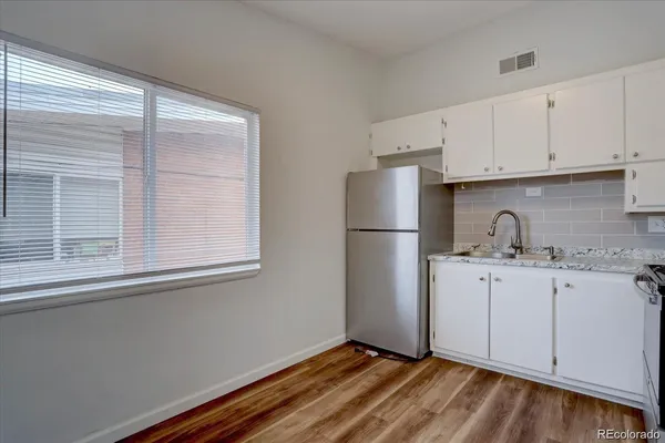 a kitchen with a sink a refrigerator and cabinets